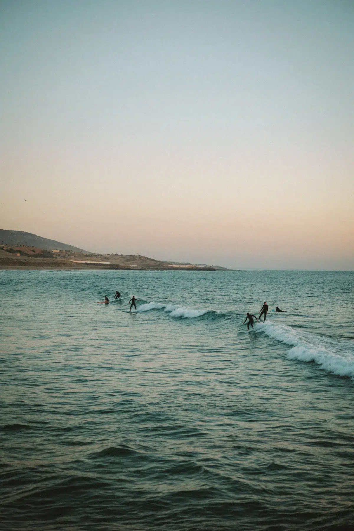 Surferzy łapiący fale przy wybrzeżu